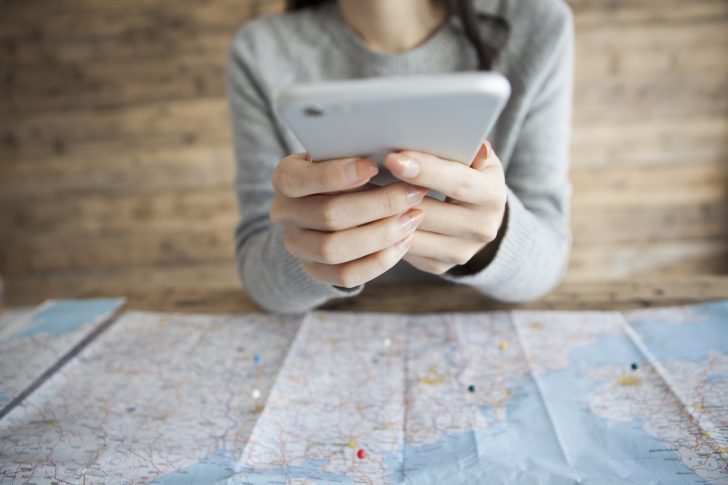 Women to expand the map, looking for the next destination in the smartphone
