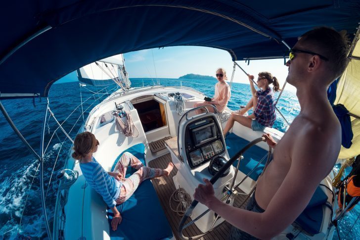 Crew of young friends sailing in a blue sea on the yacht