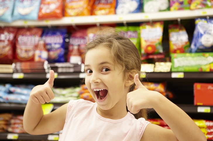 Girl in confectionery supermarket confectionery aisle